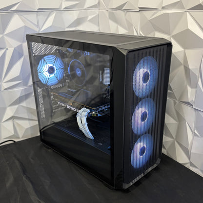 Computer case with blue LED lights on a black surface against a geometric patterned wall.