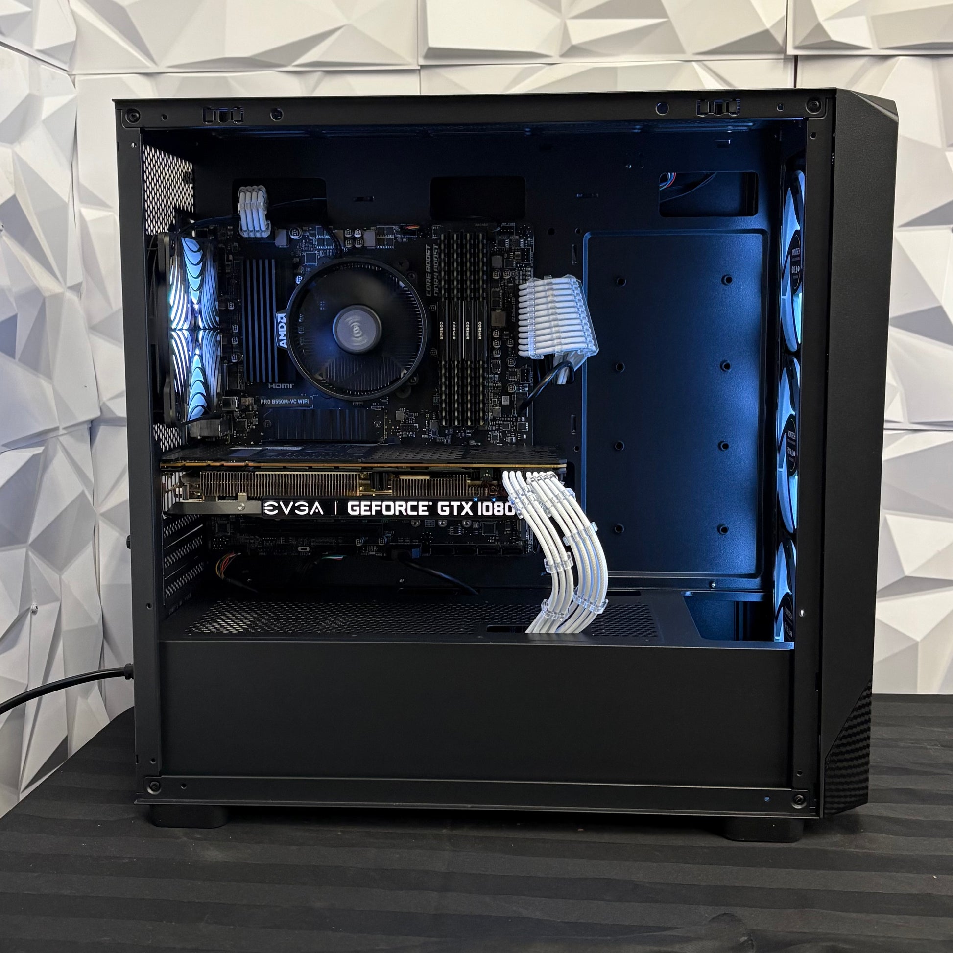 Open computer case with visible hardware components on a geometric patterned wall background