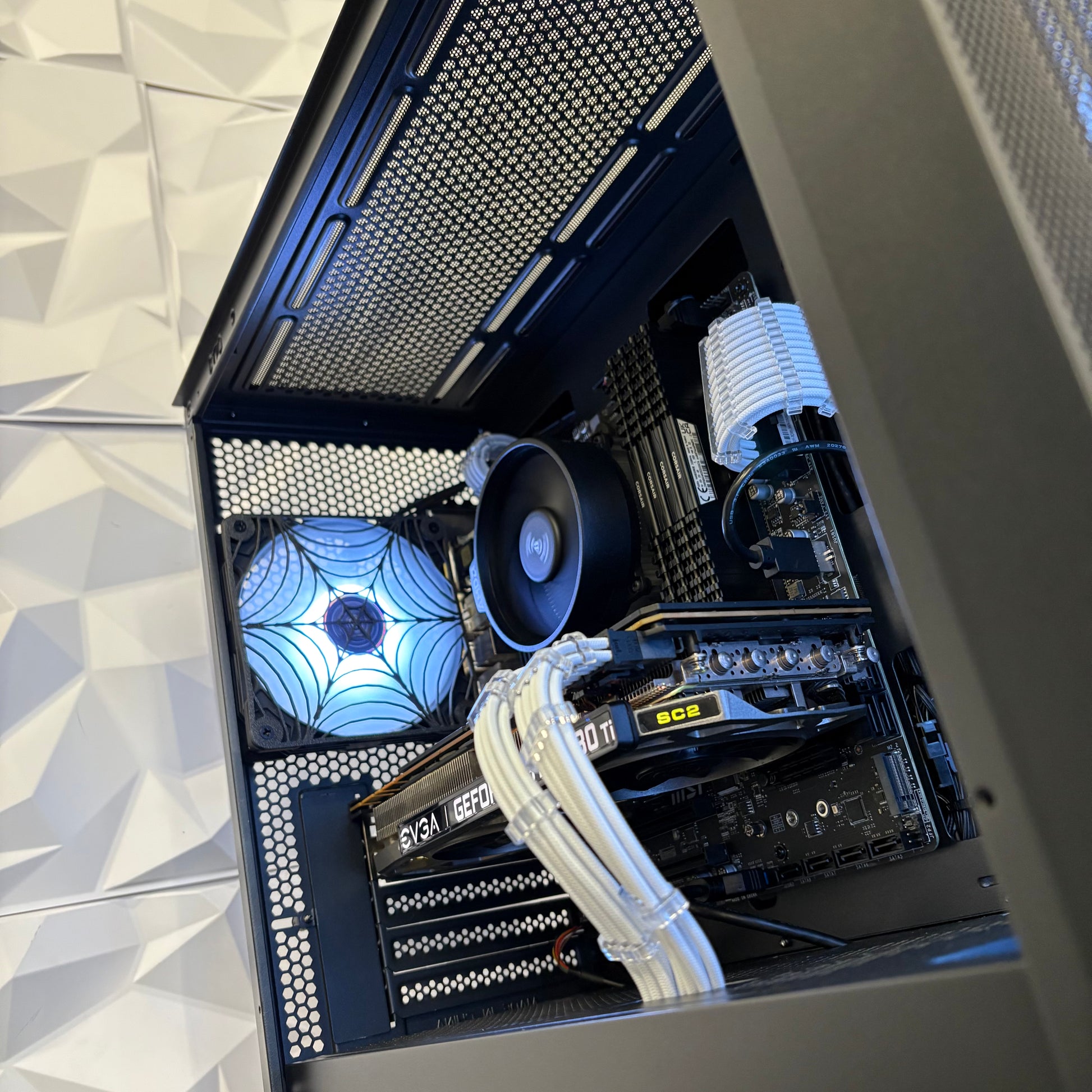 Open computer case showing internal components with a geometric pattern on the wall.