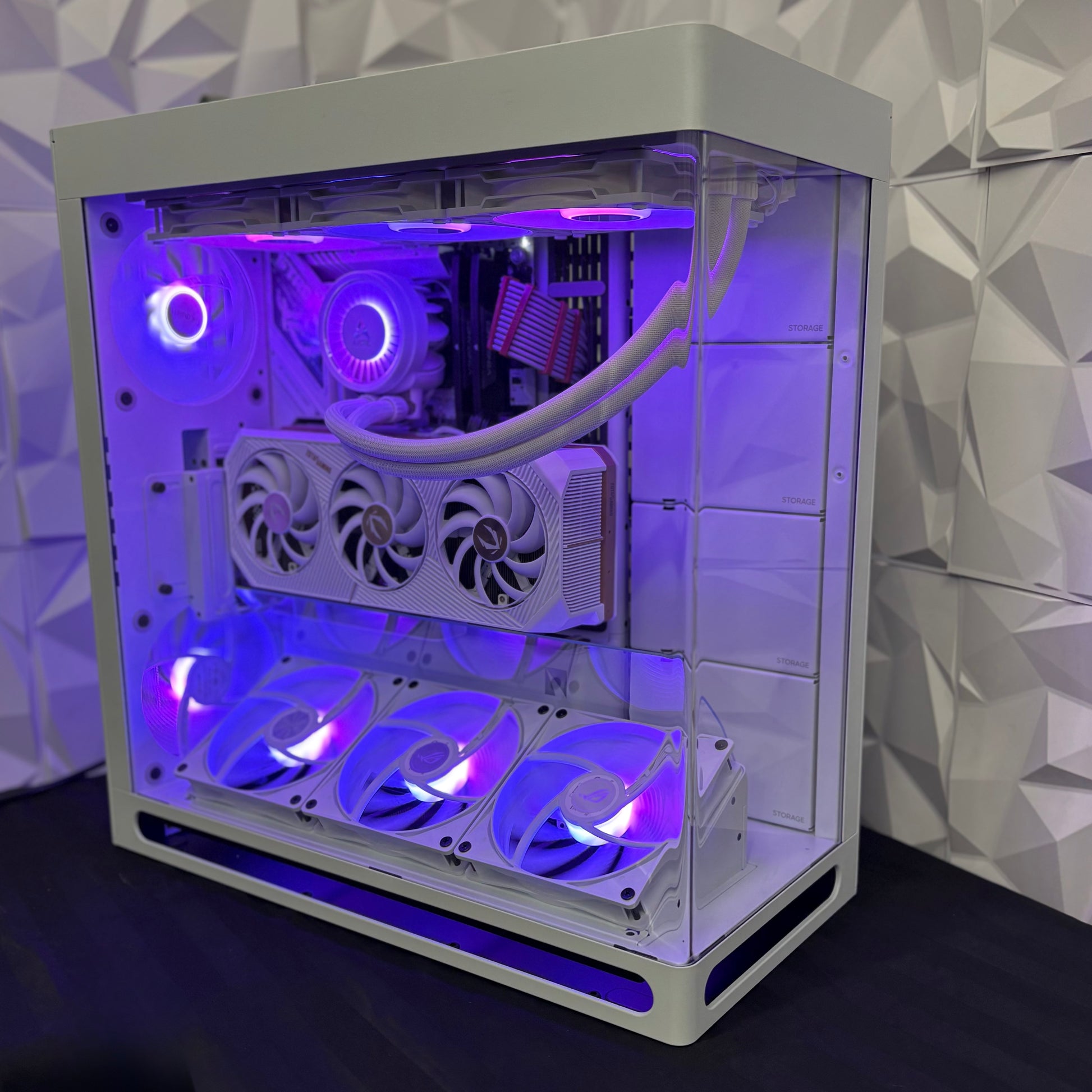 Computer case with visible internal components and purple lighting against a geometric patterned wall.