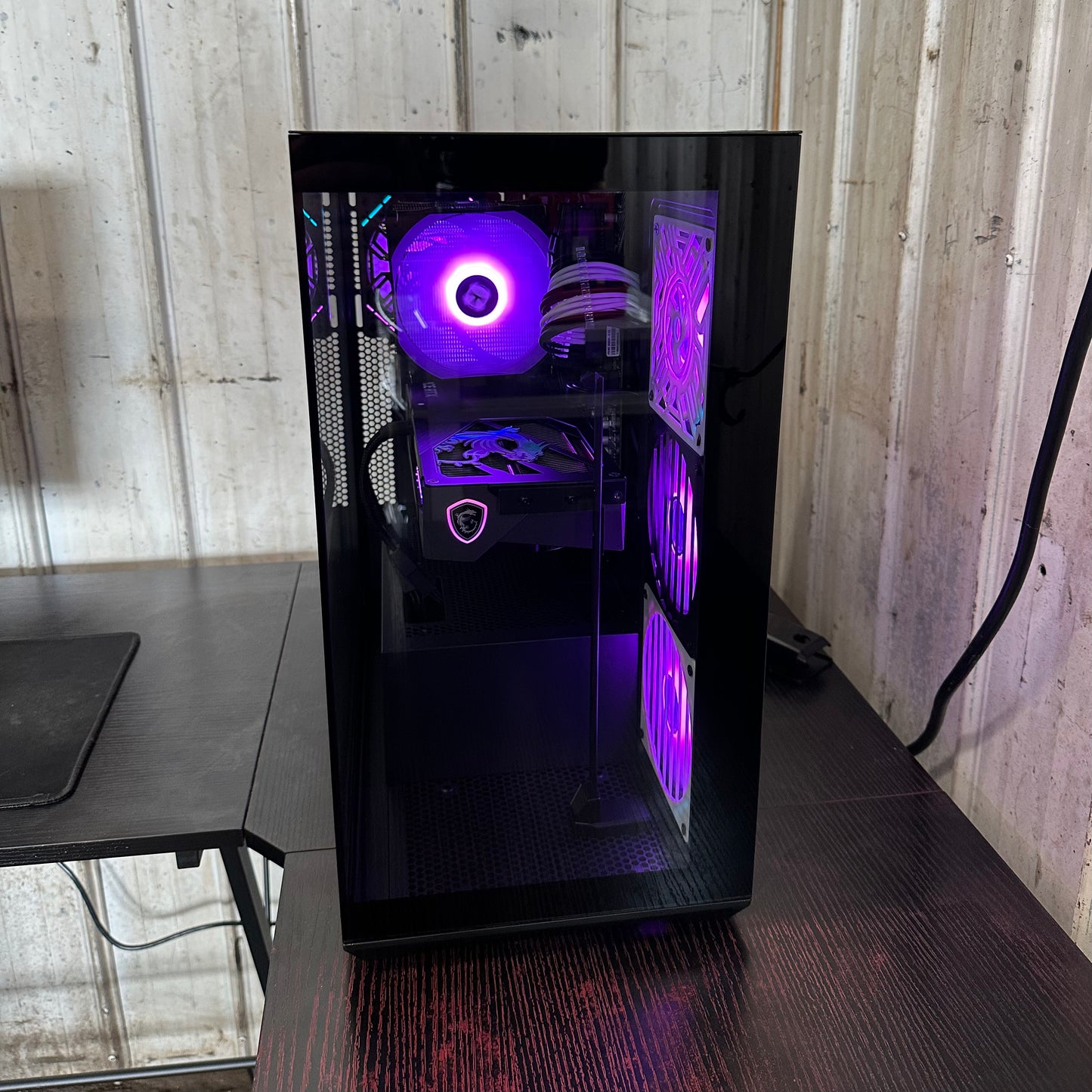 Computer case with purple lighting on a wooden surface