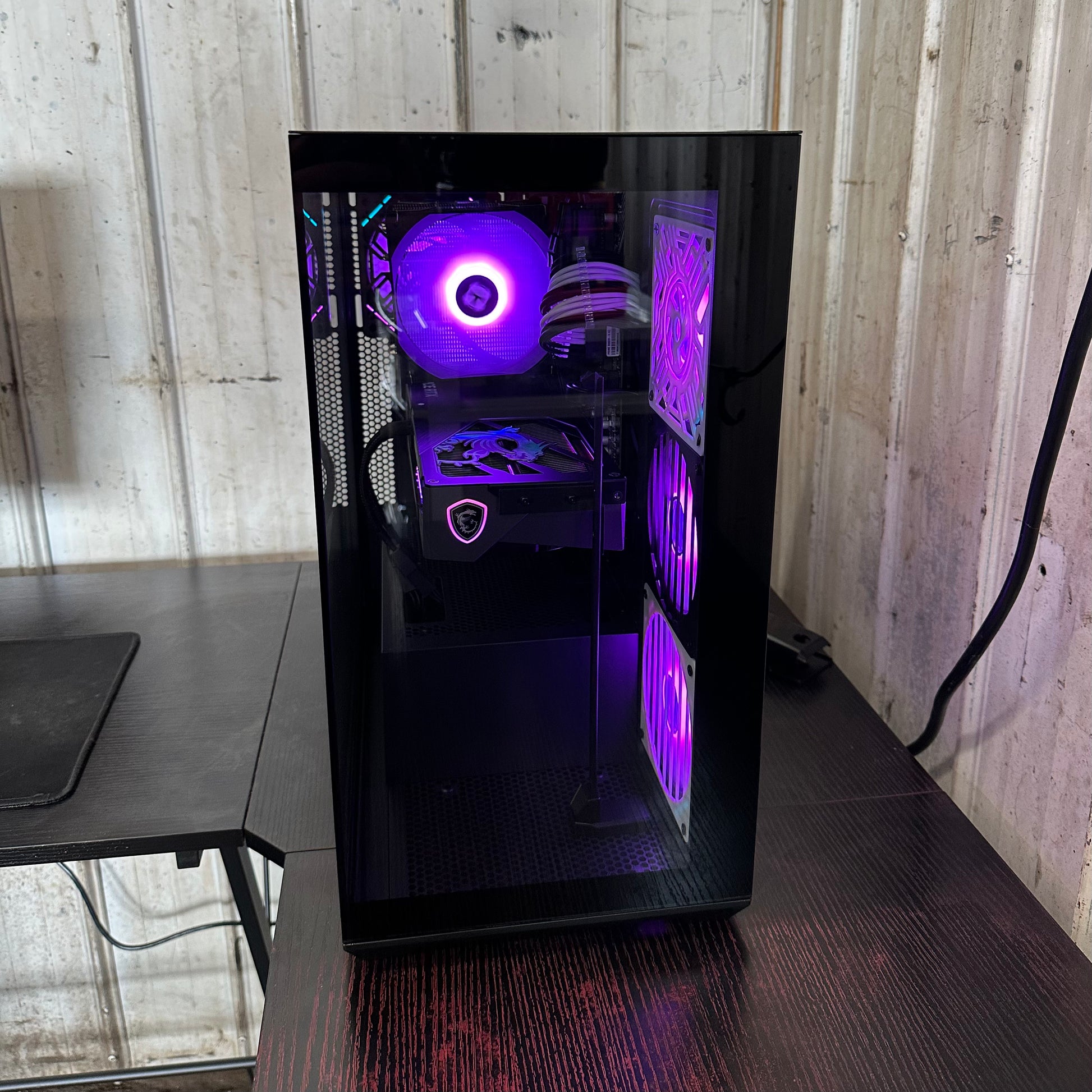 Computer case with purple lighting on a wooden surface