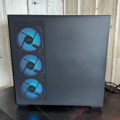 Black computer case with blue LED fans on a wooden surface