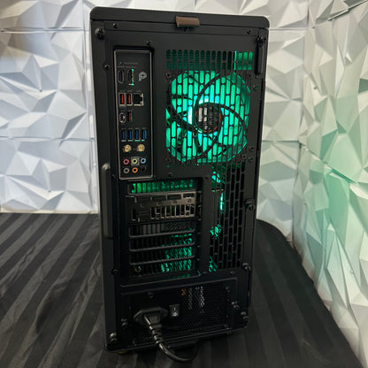 Back view of a computer case with green lighting against a geometric patterned wall.