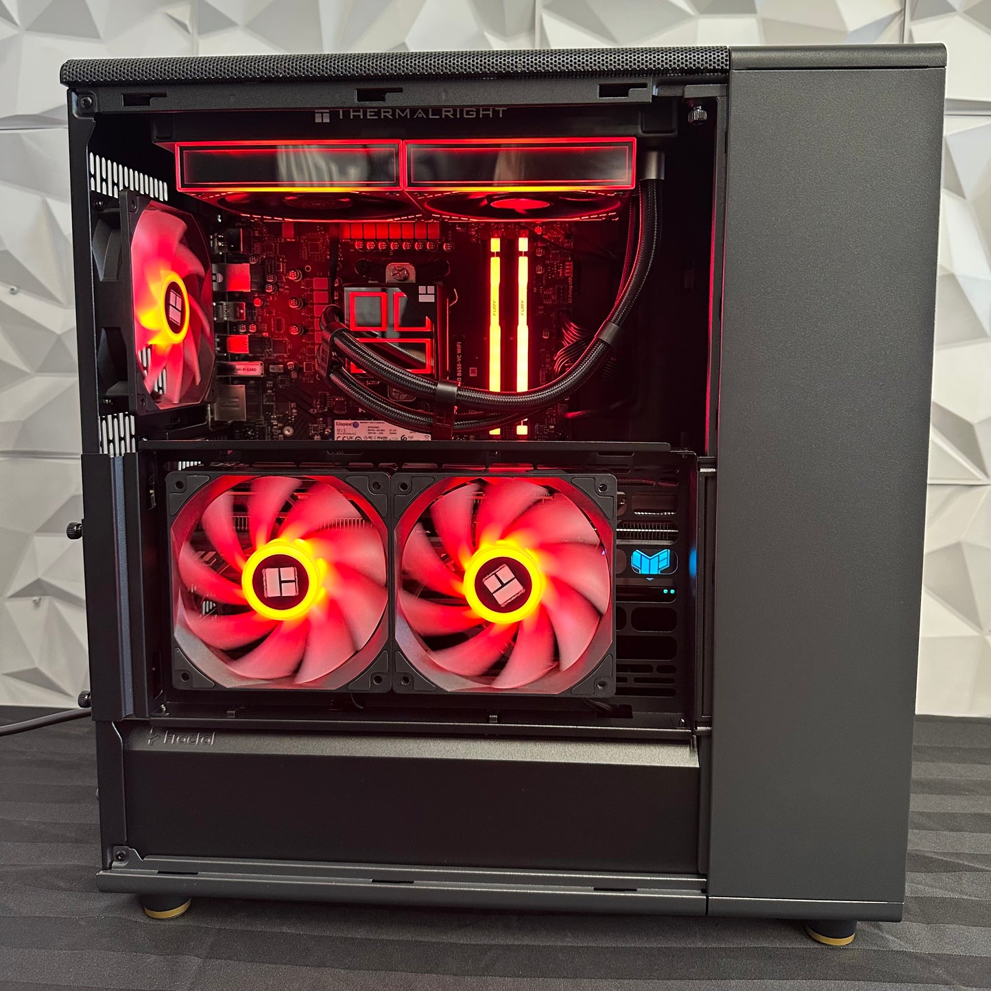 Computer case with red LED fans and visible hardware on a gray background