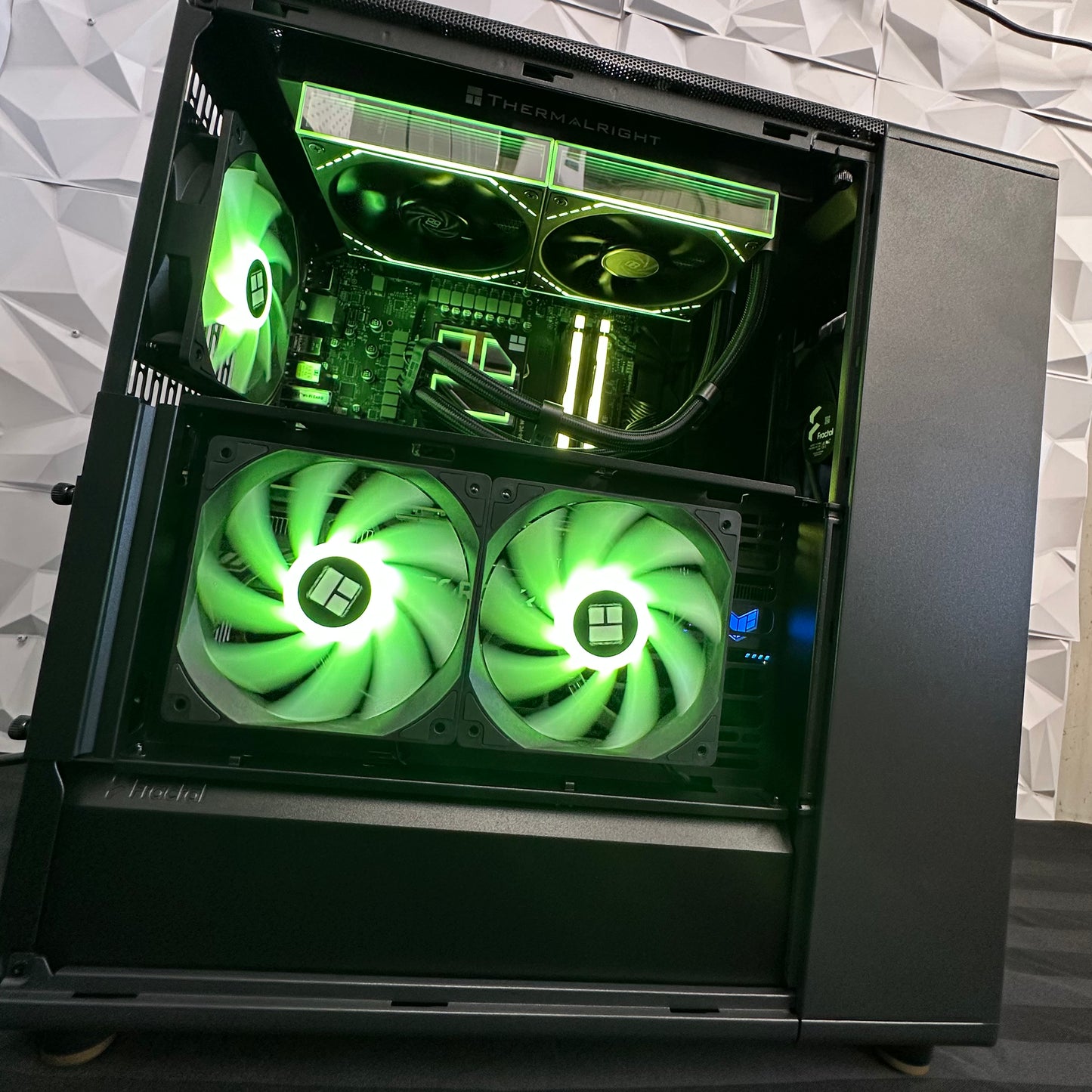 Open computer case with green LED fans and visible hardware on a white background