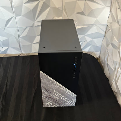 Black computer tower on a black surface with a geometric-patterned wall in the background