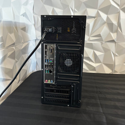 Black computer tower on a black surface with a geometric patterned wall in the background