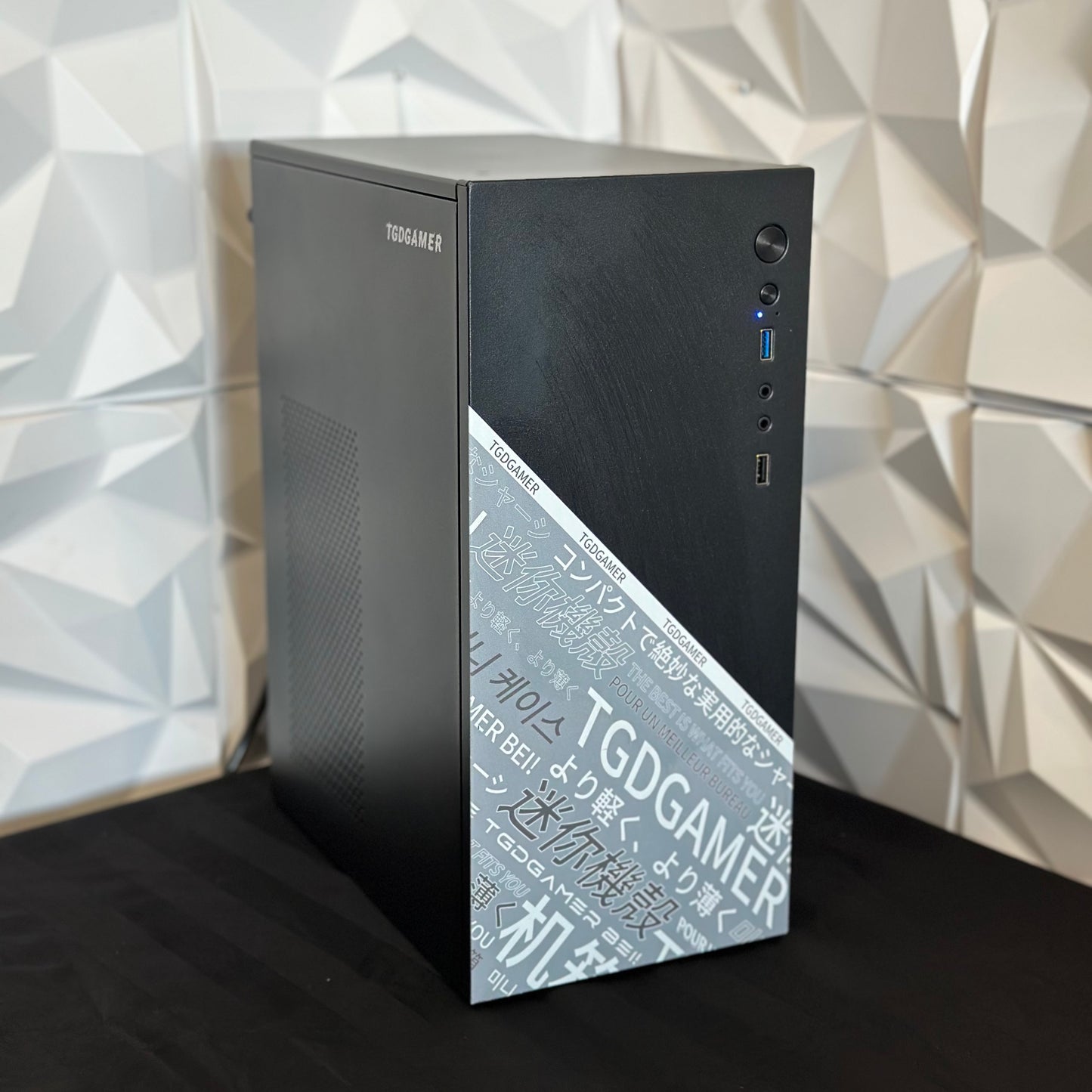 Computer tower with 'TGDGAMER' branding against a geometric-patterned wall.
