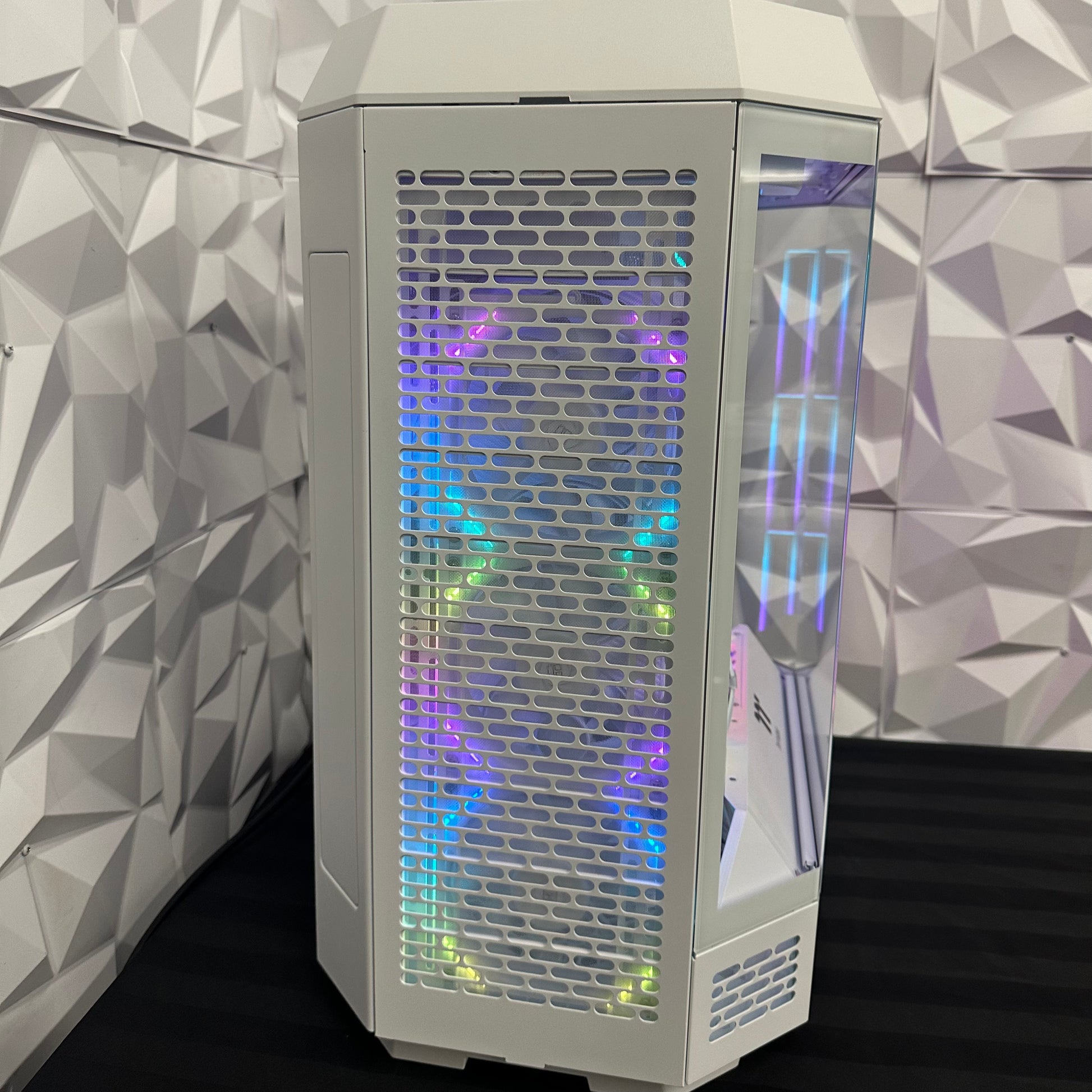 Computer tower with RGB lighting against a geometric-patterned wall