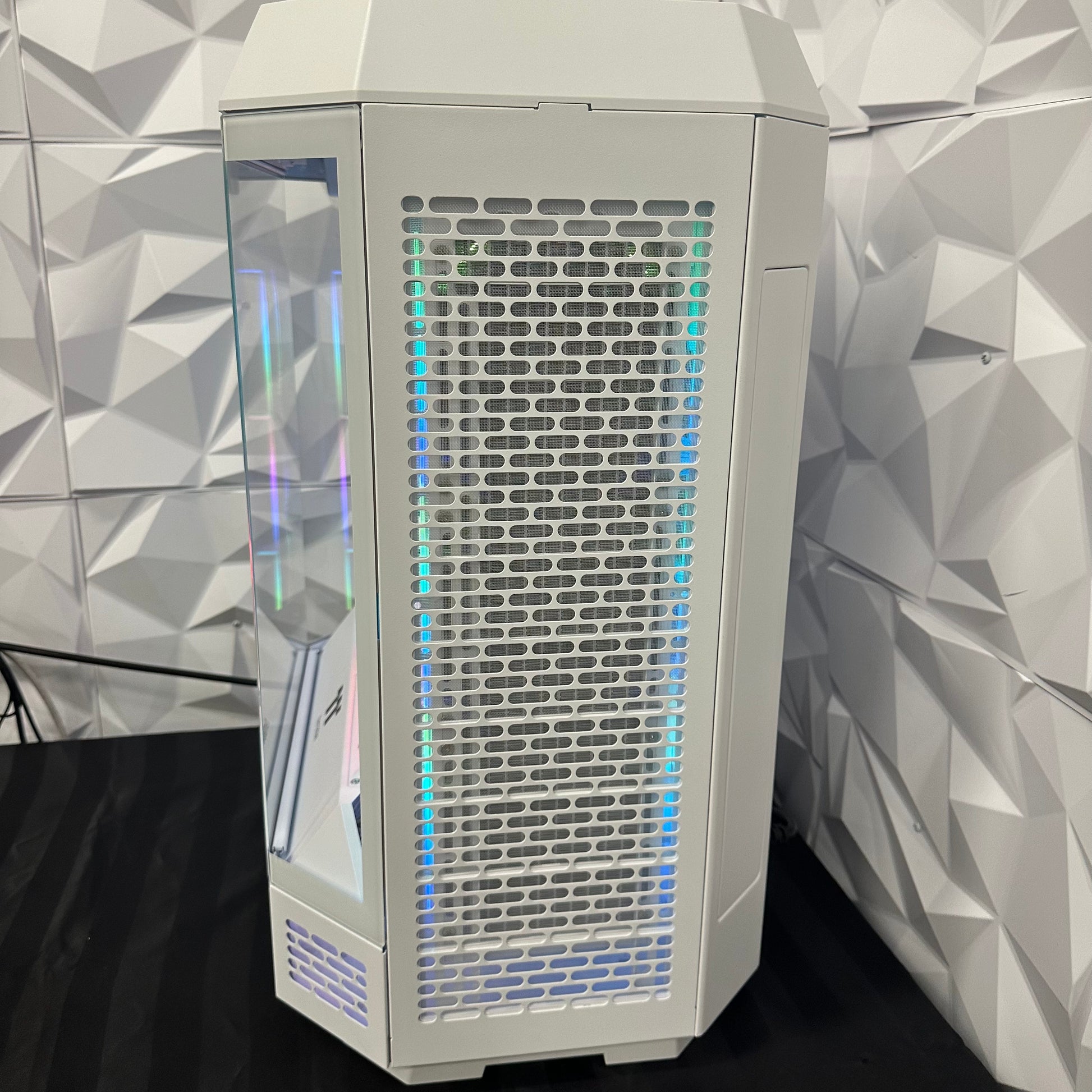 White computer case with RGB lighting on a geometric patterned wall background