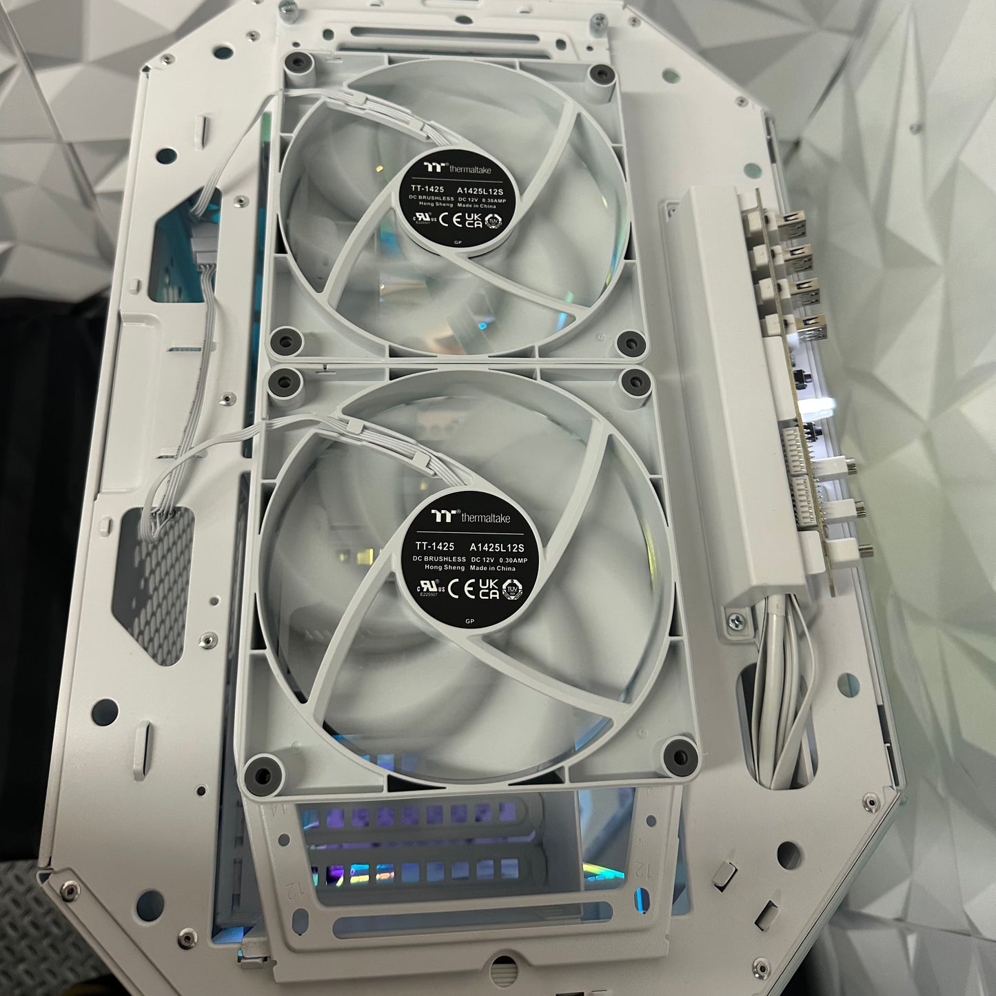 Computer case with two fans and visible branding on a geometric patterned background