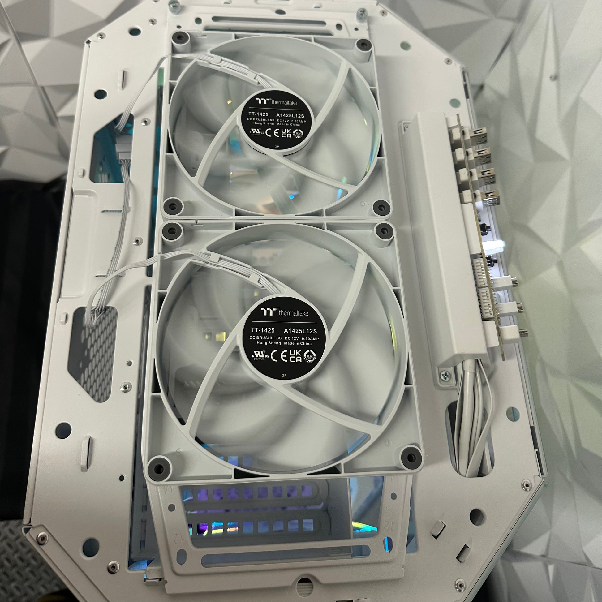 Computer case with two fans and visible branding on a geometric patterned background