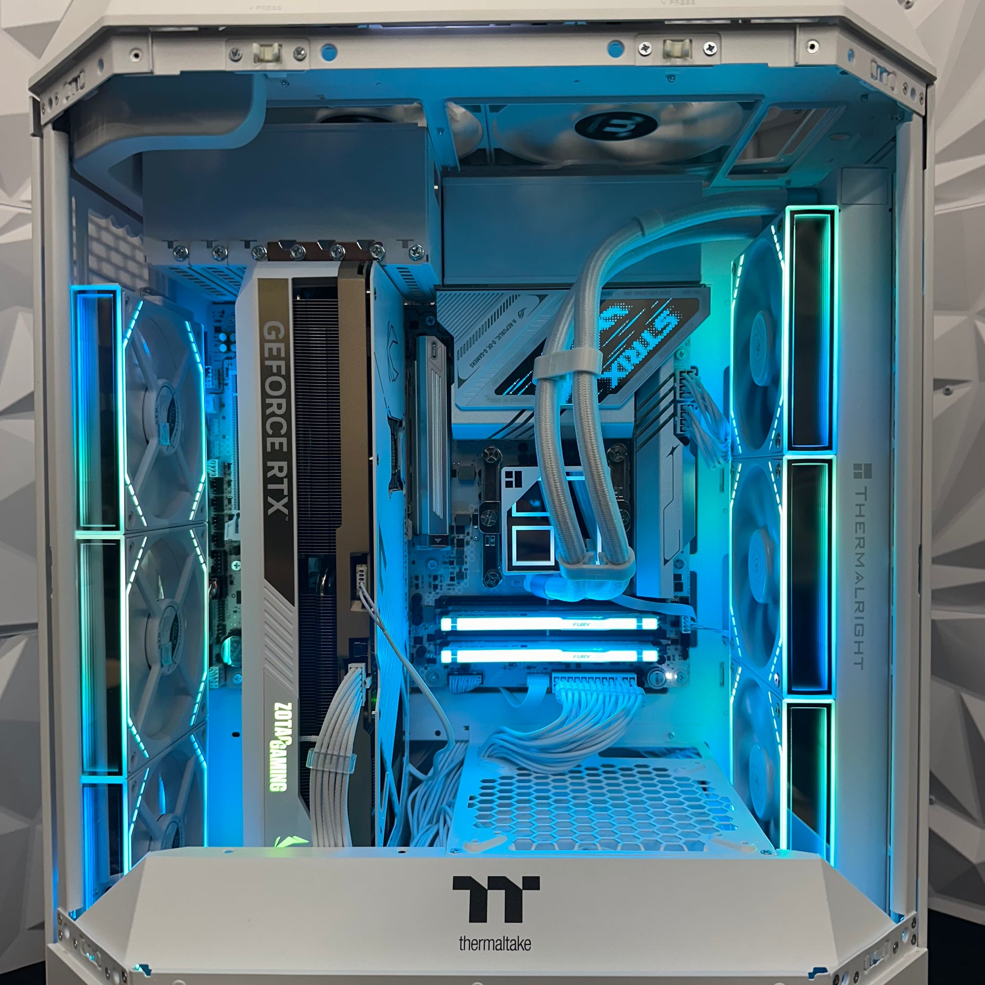 Open computer case with visible hardware components and blue lighting