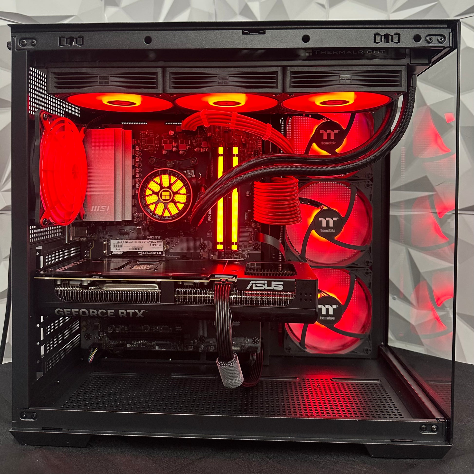 Open computer case with red LED lighting on a geometric patterned background