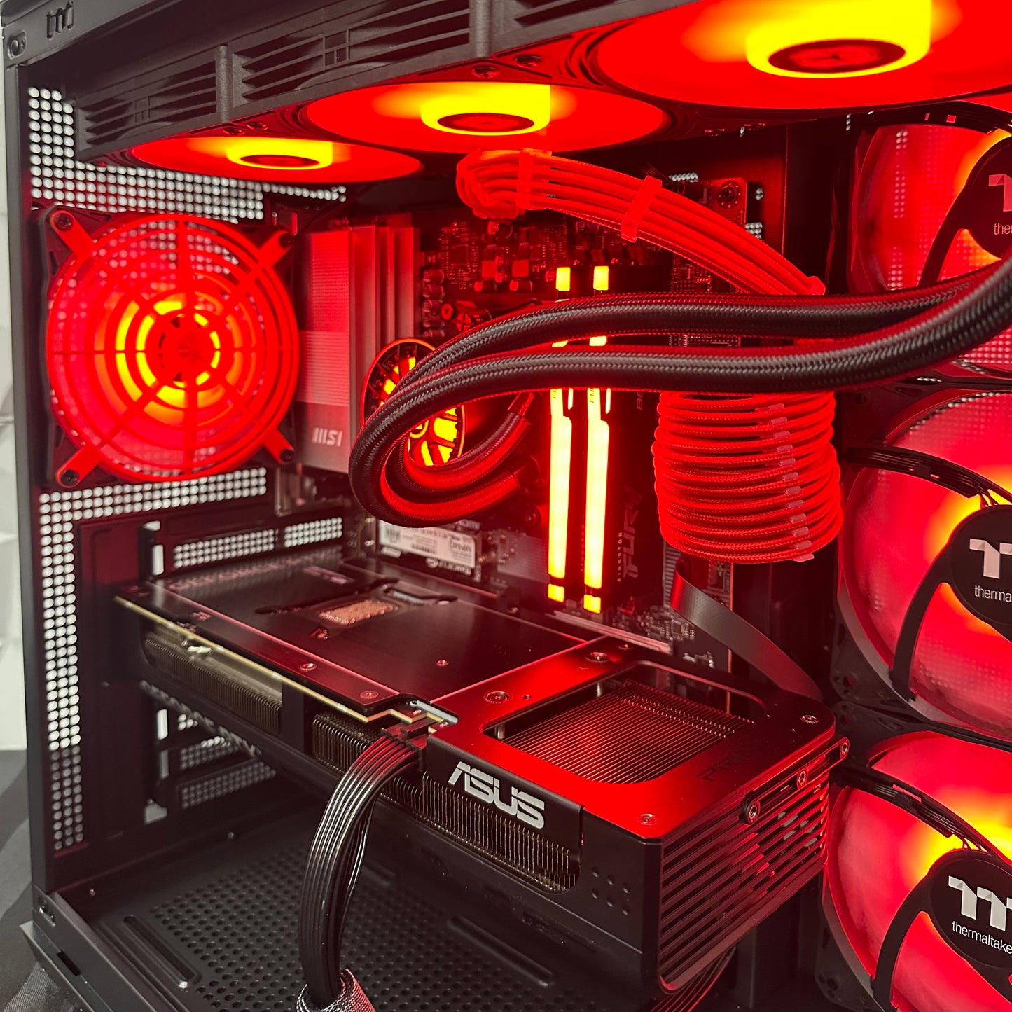Close-up of a computer case with red lighting and visible branding