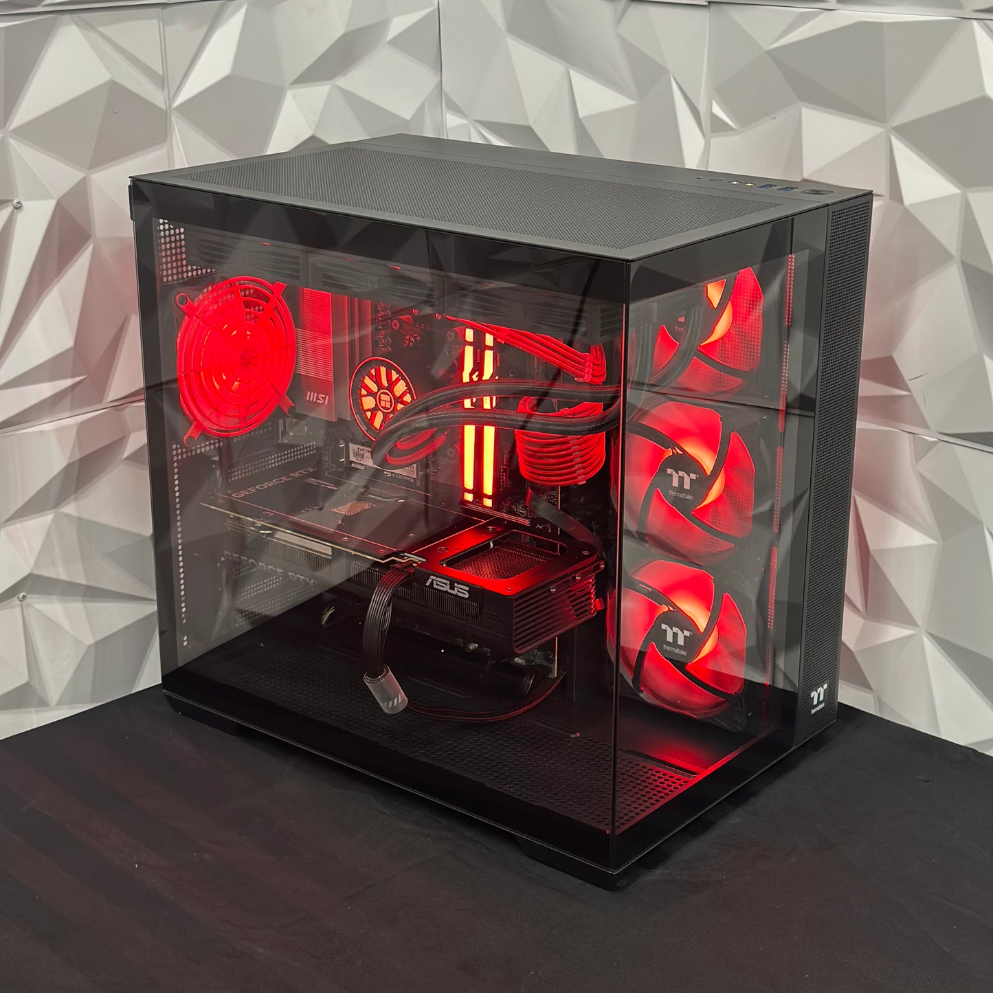 Computer case with red lighting on a geometric patterned wall background