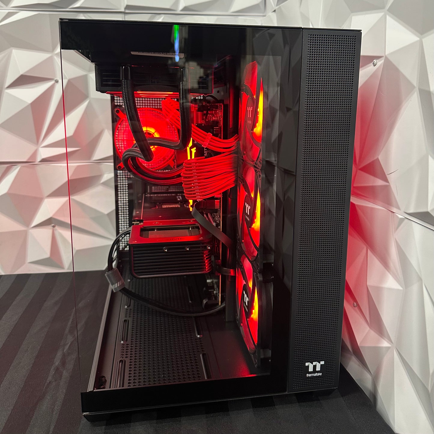 Open computer case with red lighting on a geometric patterned wall background