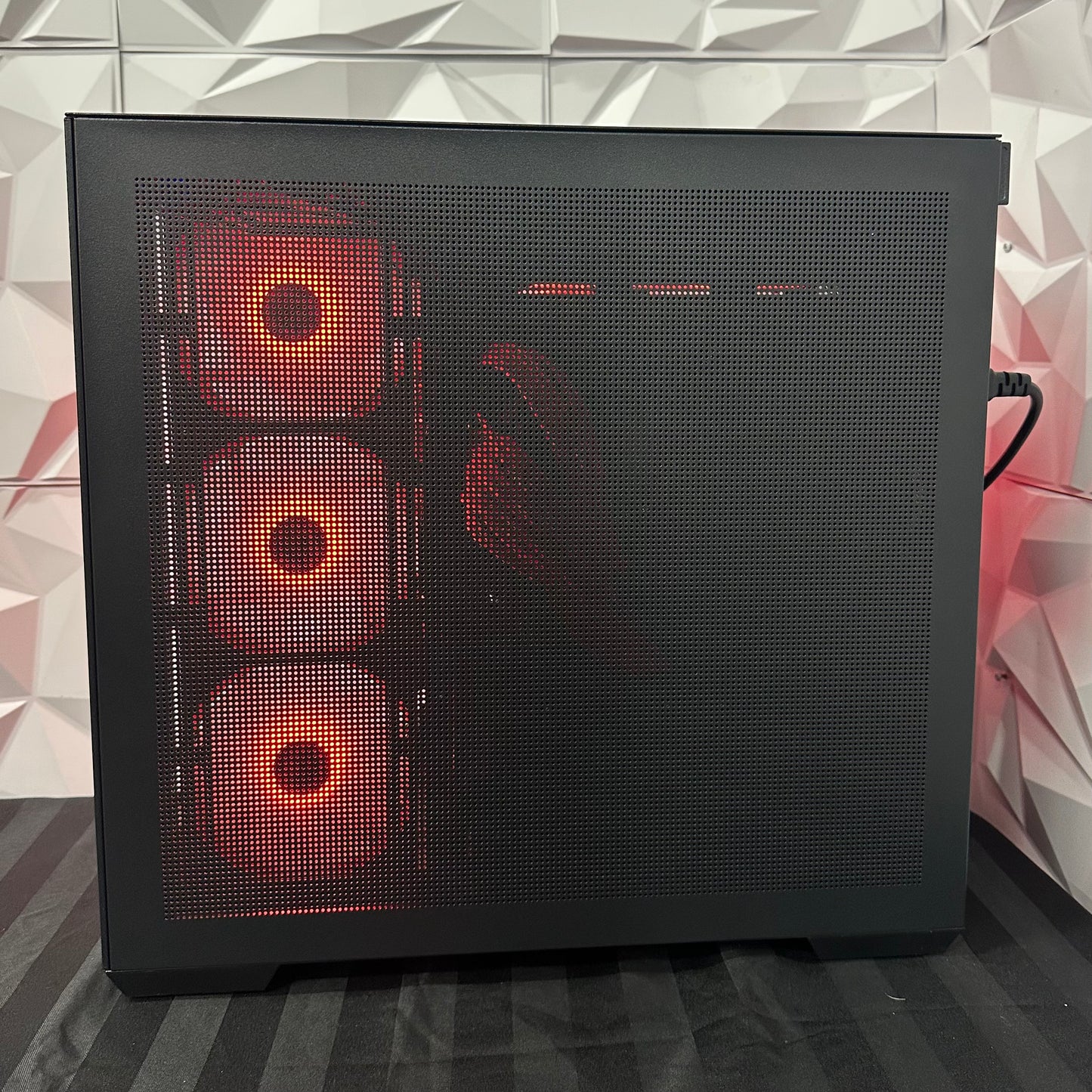 Computer case with red LED lights on a geometric patterned wall background