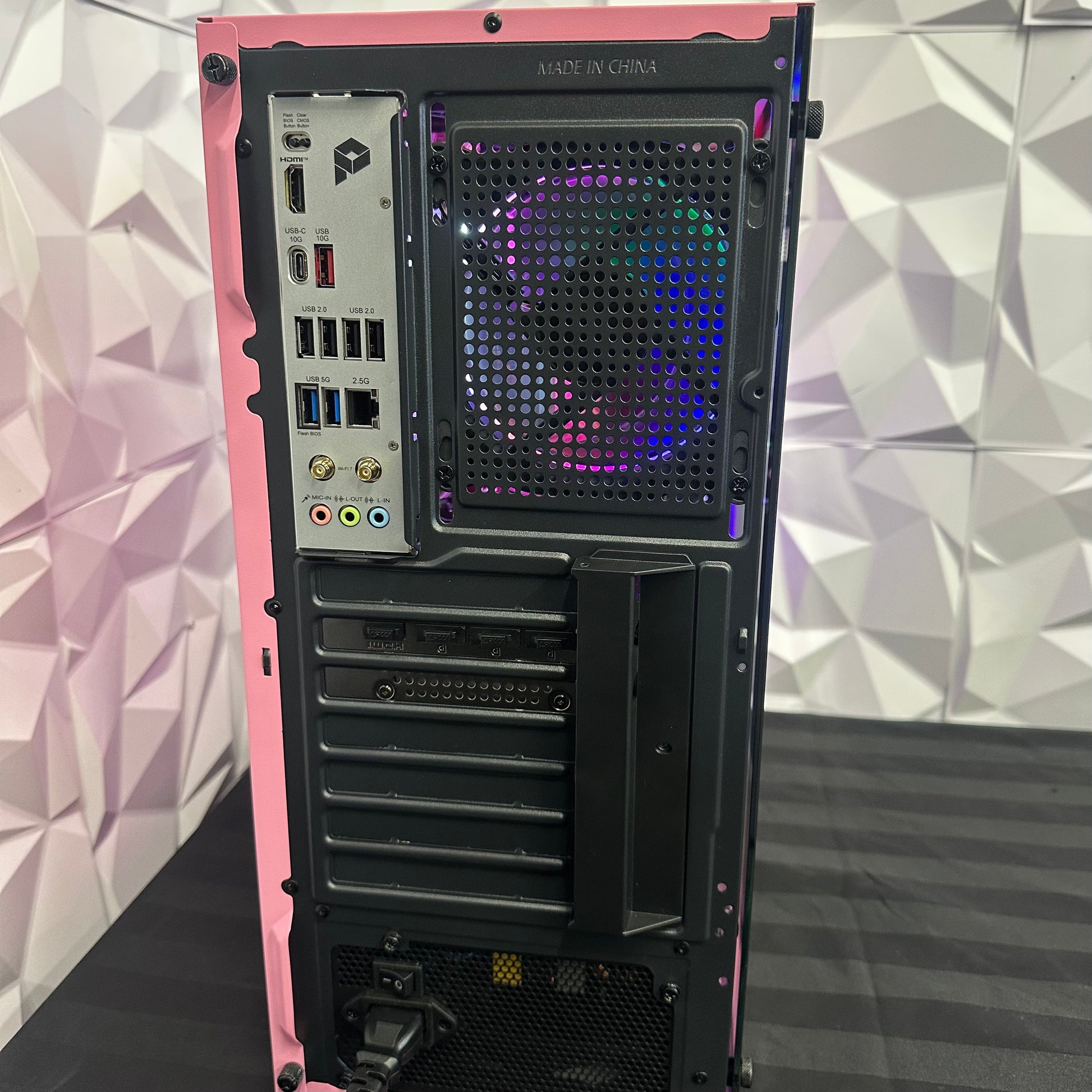 Computer tower with RGB lighting on a geometric patterned wall